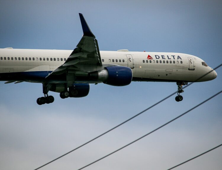 A Delta Airlines airplane getting de-iced on a snowy runway to prepare for a safe flight and avoid winter weather delays